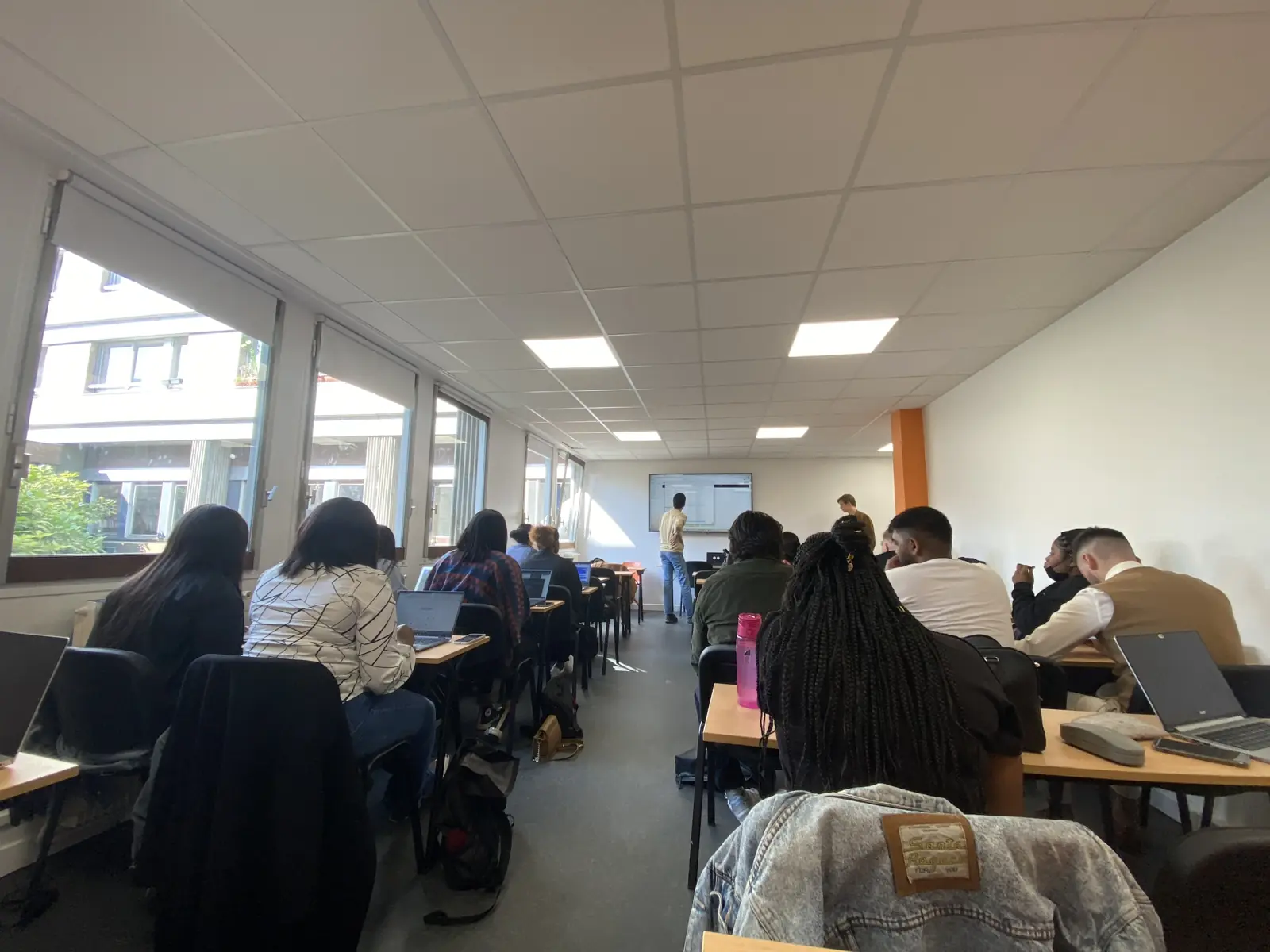 Une classe en cours, étudiants face à l'écran du formateur
